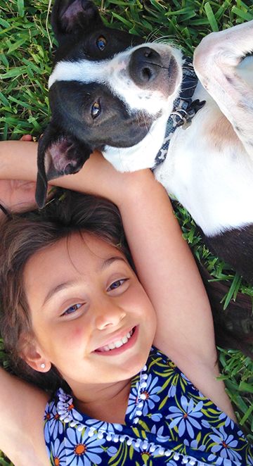 Child and dog relaxing on a pest-free lawn at a South Florida home